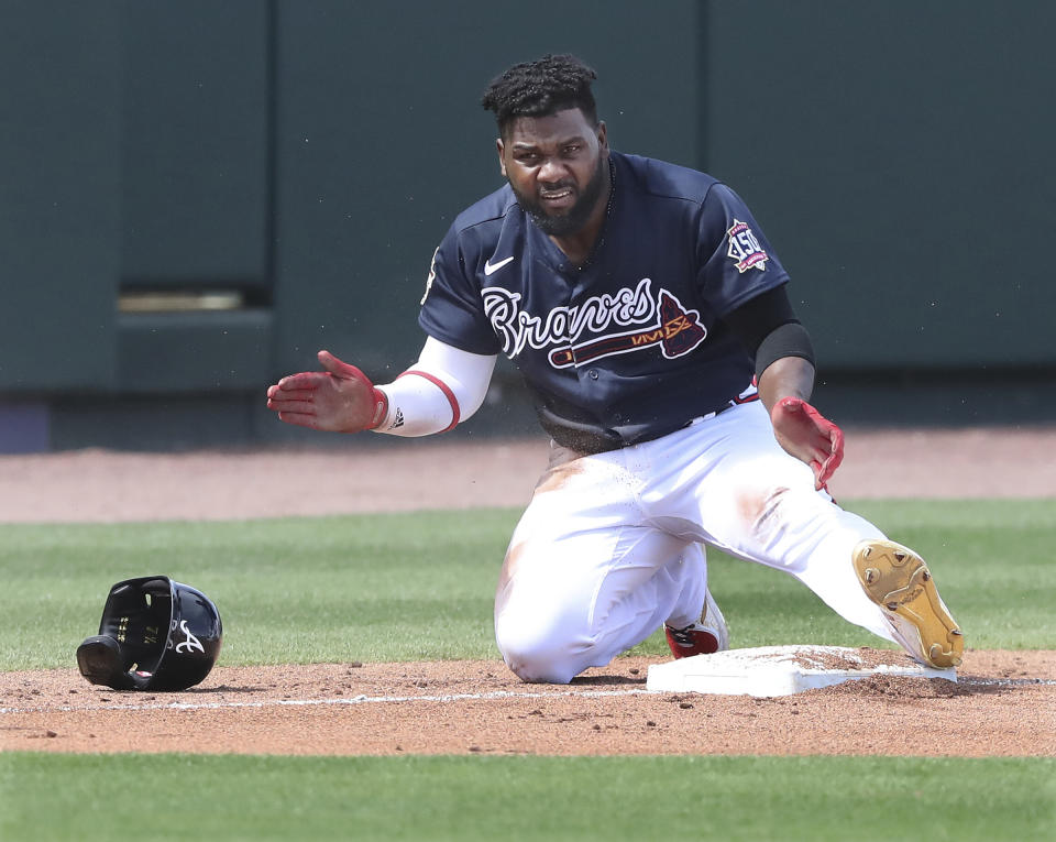 Atlanta Braves Abraham Almonte claps his hands giving himself applause getting into third base for a leadoff triple against the Minnesota Twins during the second inning of an MLB spring training game Tuesday, March 2, 2021, in North Port. (Curtis Compton/Atlanta Journal-Constitution via AP)