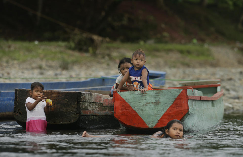 En esta imagen, tomada el 24 de mayo de 2019, un grupo de niños indígenas embera juegan en un barco y nadan en el río Tuquesa, en la provincia de Darién, Panamá. Un puñado de aldeas indígenas pueblan las orillas de los ríos Tuquesa y Chucunaque, los mismos que utilizan los migrantes al final de su travesía por Darién para llegar al norte. (AP Foto/Arnulfo Franco)