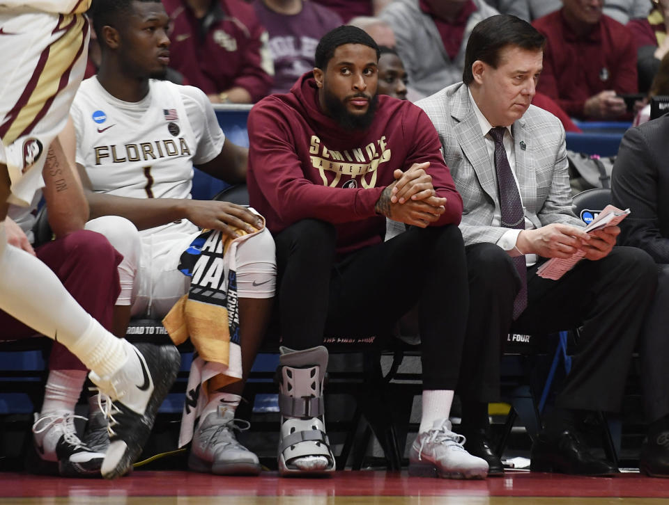 Phil Cofer, center, learned of his father's death in the locker room after Thursday's NCAA tournament game. (AP)