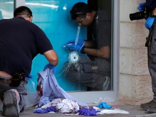 Israeli forensic police inspect the site outside a shopping mall in the occupied West Bank where Israeli-American father of four Ari Fuld was fatally stabbed on September 16, 2018
