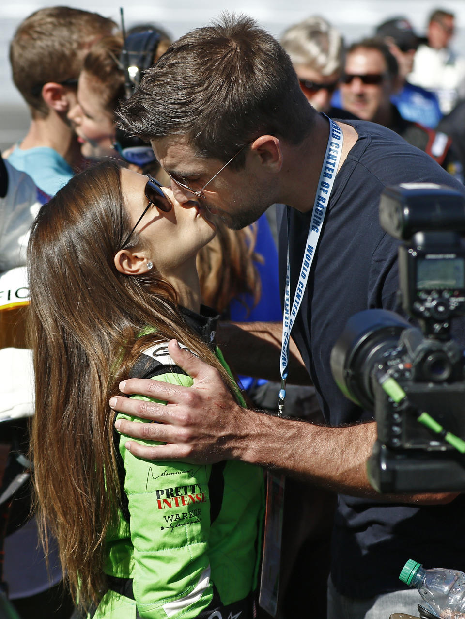 Danica Patrick, left, gets a kiss from Green Bay Packers quarterback Aaron Rodgers, right, before the NASCAR Daytona 500 Cup series auto race at Daytona International Speedway in Daytona Beach, Fla., Sunday, Feb. 18, 2018. (AP Photo/Reinhold Matay)