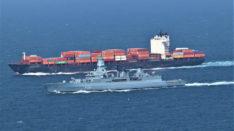 The Hessen sailing next to a merchant ship.