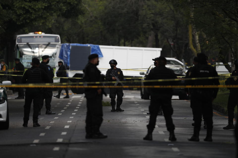 Police stand guard at a crime scene where the chief of police was attacked by gunmen in the early morning hours, in Mexico City, Friday, June 26, 2020. Heavily armed gunmen attacked and wounded Omar Garcia Harfuch in a brazen operation that left an unspecified number of dead, Mayor Claudia Sheinbaum said Friday. (AP Photo/Rebecca Blackwell)