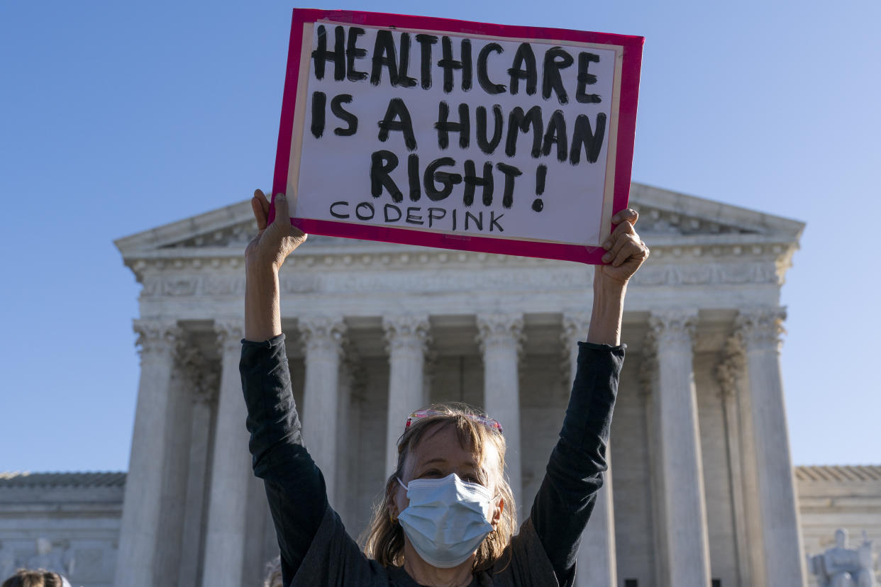 A demonstrator holds a sign in front of the U.S. Supreme Court as arguments are heard about the Affordable Care Act on Nov. 10, 2020.