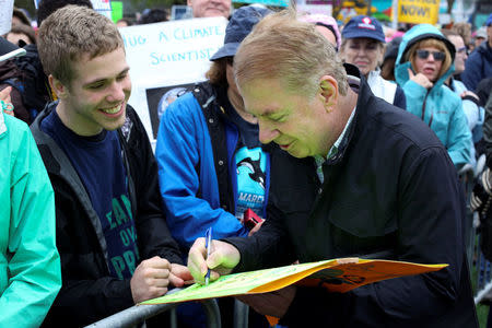 Seattle Mayor Ed Murray autographs a protestor's sign during the March For Science in Seattle, Washington, U.S. April 22, 2017. REUTERS/David Ryder