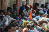 Migrant workers wait outside the Chhatrapati Shivaji Maharaj Terminus railway station before boarding trains to return to their homes after the government eased a nationwide lockdown as a preventive mearure against the COVID-19 coronavirus, in Mumbai on May 14, 2020. (Photo by Punit PARANJPE / AFP) (Photo by PUNIT PARANJPE/AFP via Getty Images)