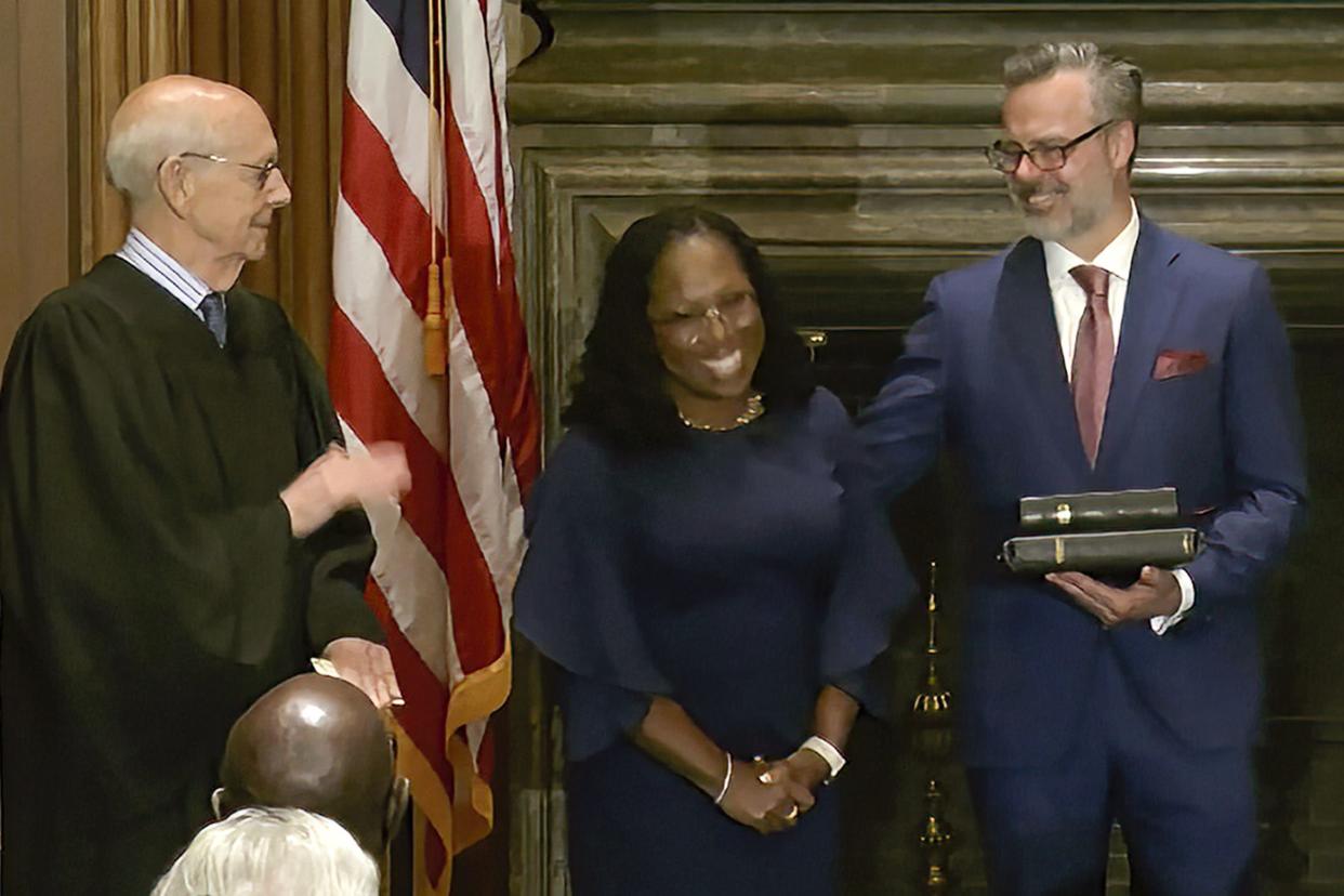 In this image from video provided by the Supreme Court, Supreme Court Justice Ketanji Brown Jackson smiles after she took the Judicial Oath from retired Supreme Court Associate Justice Stephen Breyer, left, and the Constitutional Oath from Chief Justice of the United States John Roberts, at the Supreme Court in Washington, Thursday, June 30, 2022. At right is her husband Patrick Jackson. 