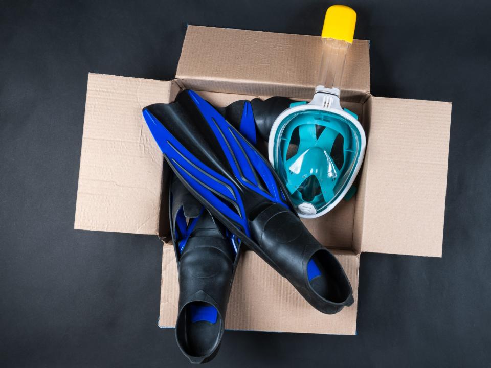 A full face snorkel mask in a box of swimming gear