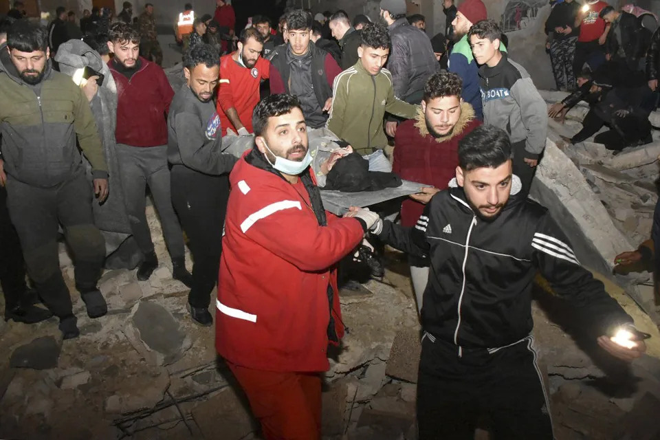 Civil defense workers and security forces search through the wreckage of collapsed buildings in Hama, Syria, Monday, Feb. 6, 2023. (SANA via AP)