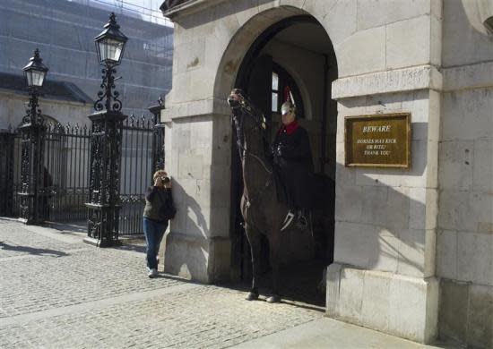 A tourist photographs a member of the Queen's Guard on horseback at the entrance to Horse Guards Parade in London March 8, 2012.