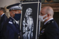 Una obra recuperada del artista británico Banksy, pintada en honor a las víctimas del ataque terrorista del 2015 en la sala de conciertos Bataclan en París, se exhibe durante una ceremonia en la embajada de Francia en Roma el martes 14 de julio de 2020. Italia devolvió a Francia la pieza robada, hallada el 10 de junio en el ático de una casa de campo en Tortoreto, en la región de Abruzzo, provincia de Teramo. (AP Foto/Domenico Stinellis)