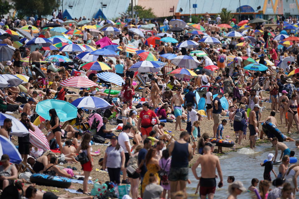 People relax on the beach at Southend-on-Sea on the Thames Estuary in Essex, Britain, Sunday July 17, 2022. The Met office has issued its first-ever “red warning” of extreme heat for Monday and Tuesday, when temperatures in southern England may reach 40 C (104 F) for the first time. (Yui Mok/PA via AP)