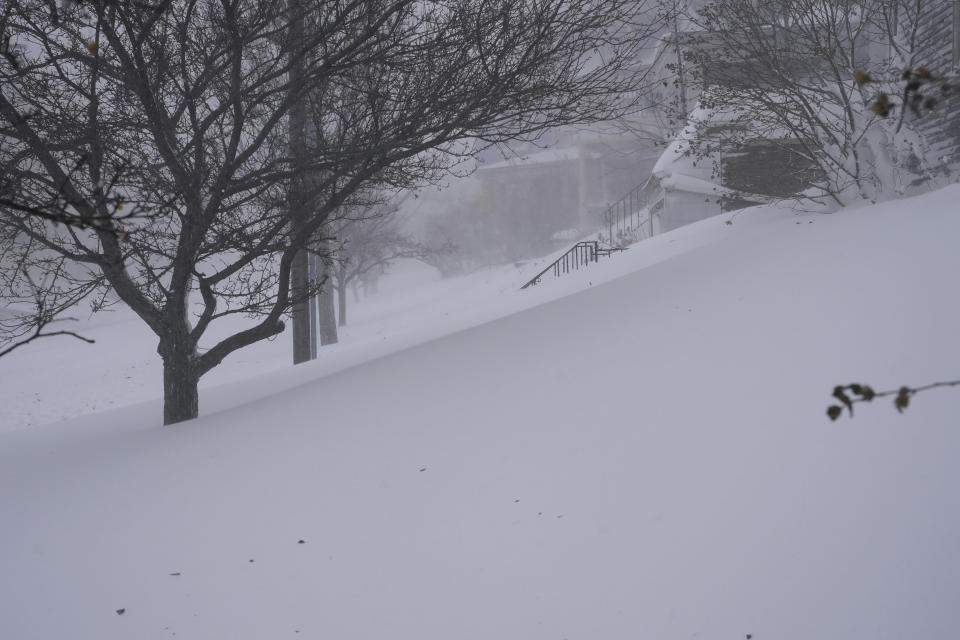 Snow drifts over the sidewalk on West Delavan Avenue in Buffalo, N.Y. on Saturday, Dec. 24, 2022. (Derek Gee/The Buffalo News via AP)