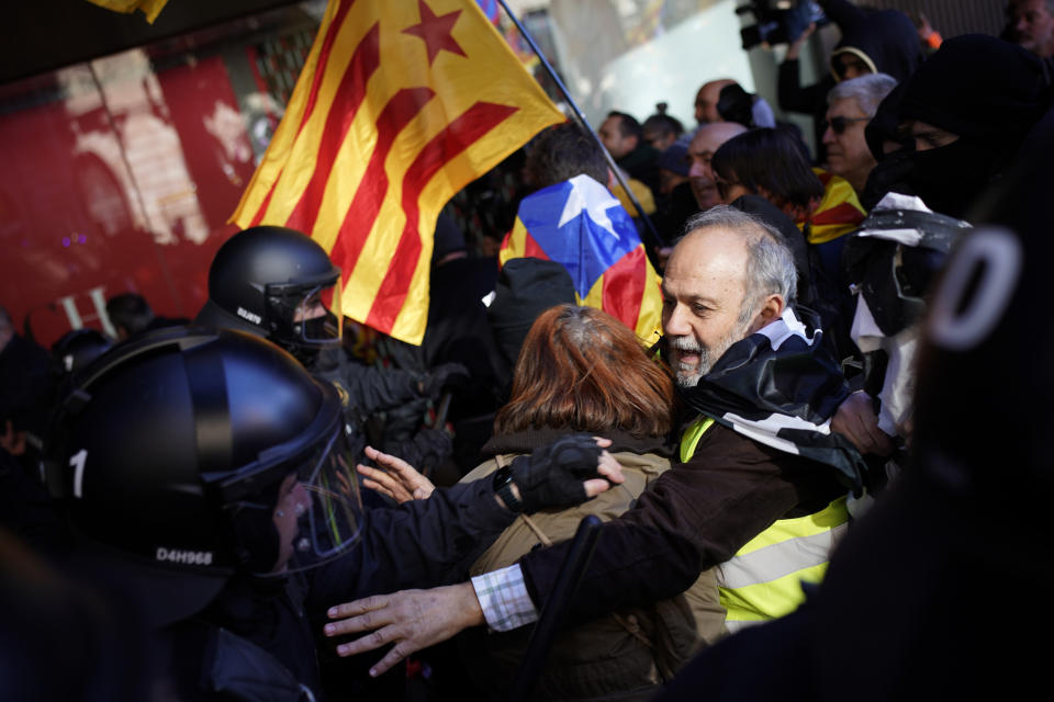 Police officers push back pro independence demonstrators during scuffles following a peaceful protest outside the Spain-France summit in Barcelona, Spain, Thursday, Jan. 19, 2023. A summit between the Spanish and French governments, led by their executive leaders, prime minister Pedro Sánchez and president Emmanuel Macron, is held in the capital of Catalonia to strengthen relations between the European neighbors by signing a friendship treaty. (AP Photo/Joan Mateu Parra)