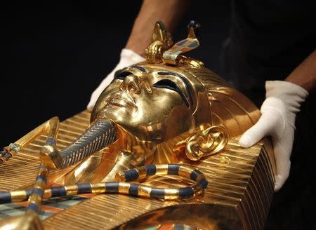 A worker arranges a replica of a sarcophage of Pharaoh Tutankhamun ahead of the opening of a major exhibition on the Ancient Egypt called 'Tutankhamun, his Tomb and his Treasures' in Brussels April 11, 2011. REUTERS/Yves Herman/Files