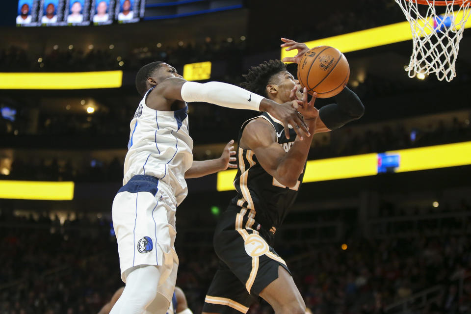 Dallas Mavericks forward Dorian Finney-Smith (10) fouls Atlanta Hawks guard Cam Reddish (22) in the first half of an NBA basketball game Saturday, Feb. 22, 2020, in Atlanta, Ga. (AP Photo/Brett Davis)