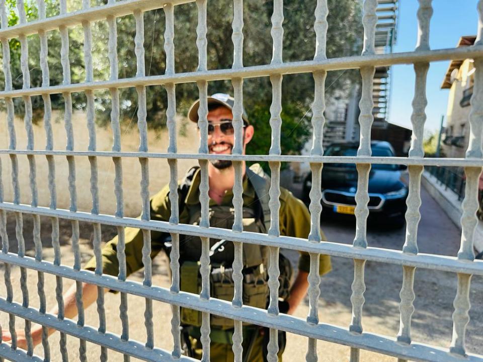 Settler Jonathan Landman speaks with CBS News through the fence that separates Palestinian Sa'adat Gharib's family home from the surrounding Israeli settlement in East Jerusalem, Nov. 9, 2023. / Credit: CBS News/Agnes Reau