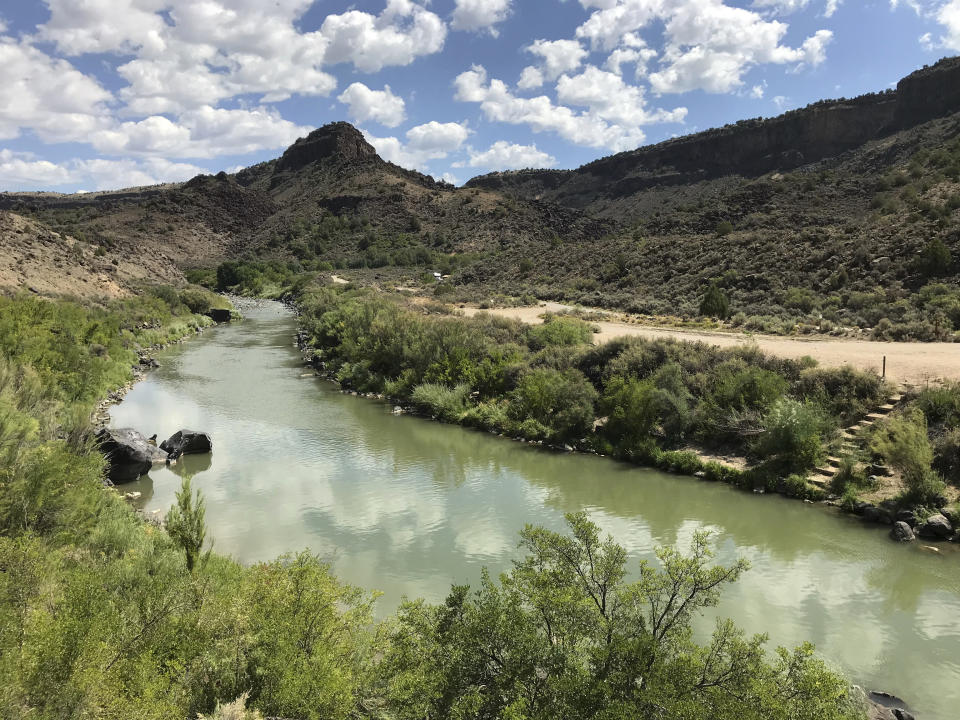 This Aug. 6, 2018, photo shows the Rio Grande flowing south of Taos, New Mexico. A recent report by the U.S. Geological Survey found that investments made to reduce the risk of wildfire and to protect water sources in the West are paying dividends by creating jobs and infusing money into local economies. The study focused on several counties along the New Mexico-Colorado border that make up the watershed of the Rio Grande, one of North America's longest rivers. (AP Photo/Susan Montoya Bryan)