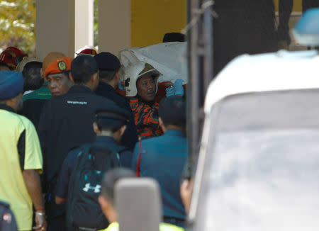 Firefighters carry a body out of religious school Darul Quran Ittifaqiyah after a fire broke out in Kuala Lumpur, Malaysia September 14, 2017. REUTERS/Lai Seng Sin