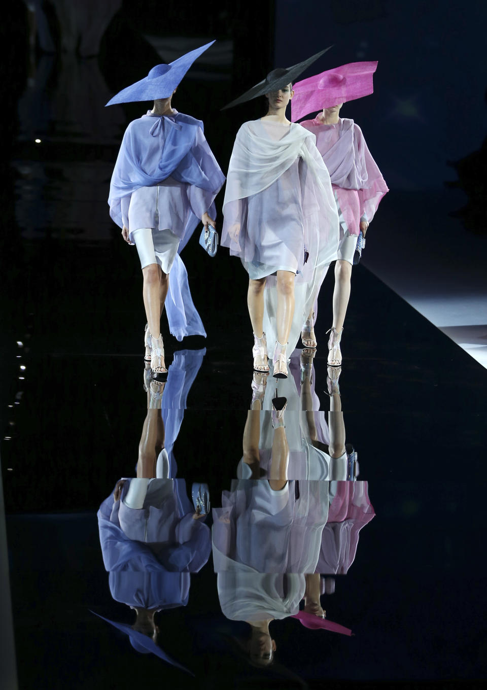 Models wear creations for Giorgio Armani's women's Spring-Summer 2014 collection, part of the Milan Fashion Week, unveiled in Milan, Italy, Monday, Sept. 23, 2013. (AP Photo/Antonio Calanni)