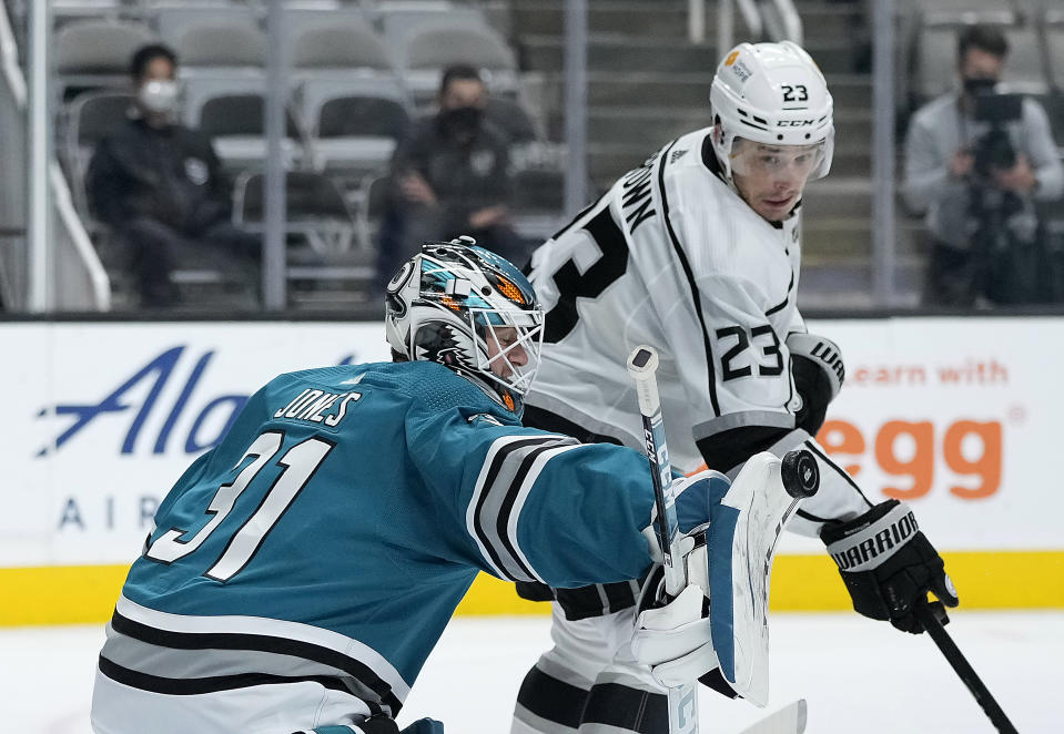 San Jose Sharks goaltender Martin Jones (31) blocks a shot as Los Angeles Kings right wing Dustin Brown (23) looks for a rebound during the second period of an NHL hockey game Saturday, April 10, 2021, in San Jose, Calif. (AP Photo/Tony Avelar)