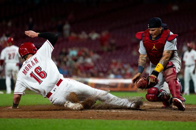 St. Louis Cardinals catcher Yadier Molina adjusts his mask as he