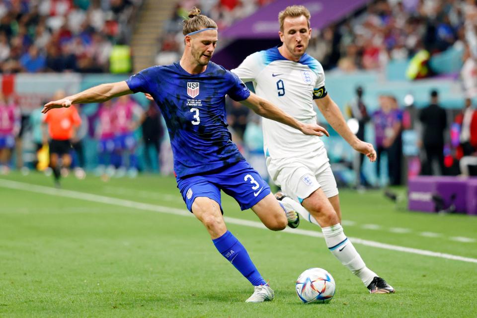 U.S. defender Walker Zimmerman, left, dribbles the ball while England forward Harry Kane gives chase during the second half of their group stage match of the 2022 World Cup on Saturday in Qatar.