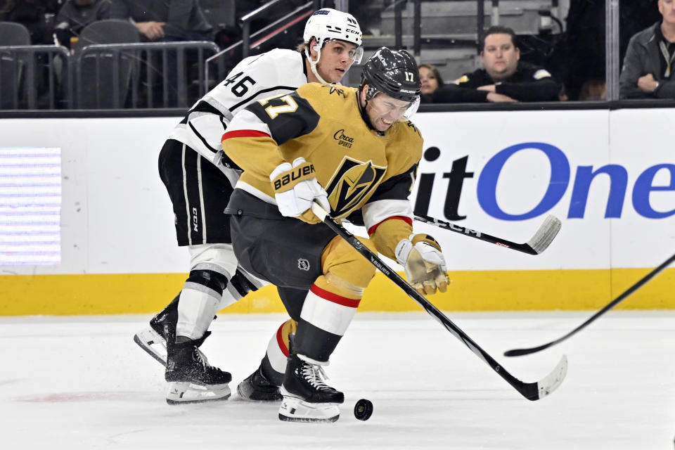 Los Angeles Kings center Blake Lizotte (46) and Vegas Golden Knights defenseman Shea Theodore (27) battle for the puck during the first period of an NHL hockey game Thursday, Dec. 28, 2023, in Las Vegas. (AP Photo/David Becker)