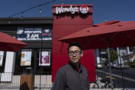 Lawrence Cheng, whose family owns seven Wendy's locations south of Los Angeles, stands for a photo outside his Wendy's restaurant in Fountain Valley, Calif., June 20, 2024. Cheng used to have nearly a dozen employees at the location during the day. Now, he only schedules seven for each shift as he scrambles to absorb a dramatic jump in labor costs after a new California law boosted the hourly wage for fast food workers on April 1 from $16 to $20 an hour. (AP Photo/Jae C. Hong)