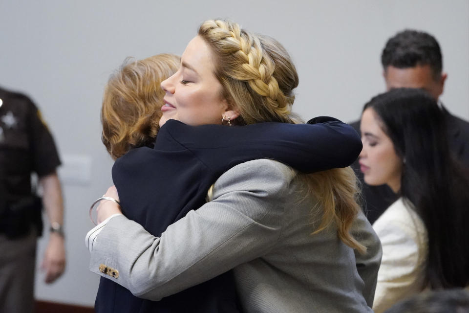 Actor Amber Heard hugs her attorney attorney Elaine Bredehoft in the courtroom at the Fairfax County Circuit Courthouse in Fairfax, Va., Friday, May 27, 2022. Actor Johnny Depp sued his ex-wife Amber Heard for libel in Fairfax County Circuit Court after she wrote an op-ed piece in The Washington Post in 2018 referring to herself as a "public figure representing domestic abuse." (AP Photo/Steve Helber, Pool)