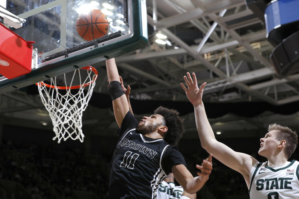 Brown's Malachi Ndur, left, gets a layup in front of Michigan State's Jaxon Kohler during the first half of an NCAA college basketball game, Saturday, Dec. 10, 2022, in East Lansing, Mich. (AP Photo/Al Goldis)