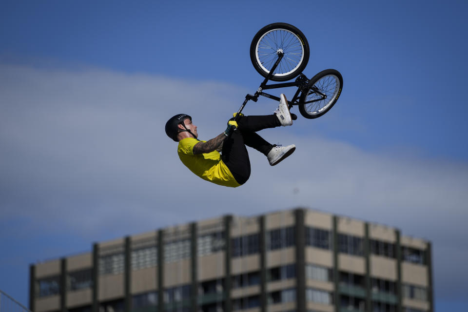 Logan Martin of Australia makes a jump with a nearby apartment building seen in the background, during a BMX Freestyle training session at the 2020 Summer Olympics, Tuesday, July 27, 2021, in Tokyo, Japan. (AP Photo/Ben Curtis)