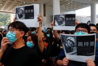 Students hold images of Chow Tsz-Lok, 22, a university student who fell during protests at the weekend and died early on Friday morning, during a ceremony to pay tribute to him at the Hong Kong University of Science and Technology