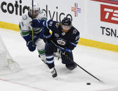 Winnipeg Jets' Kyle Connor (81) looks to pass the puck as Vancouver Canucks' Quinn Hughes (43) defends during the second period of an NHL game in Winnipeg, Manitoba, Monday, May 10, 2021. (Fred Greenslade/The Canadian Press via AP)