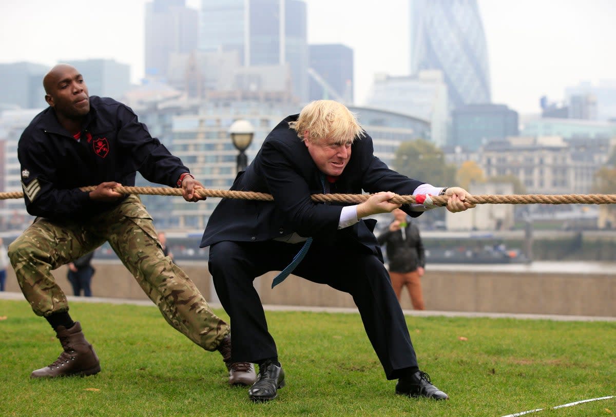 Boris Johnson gets stuck in with a tug of war alongside troops in London (PA)
