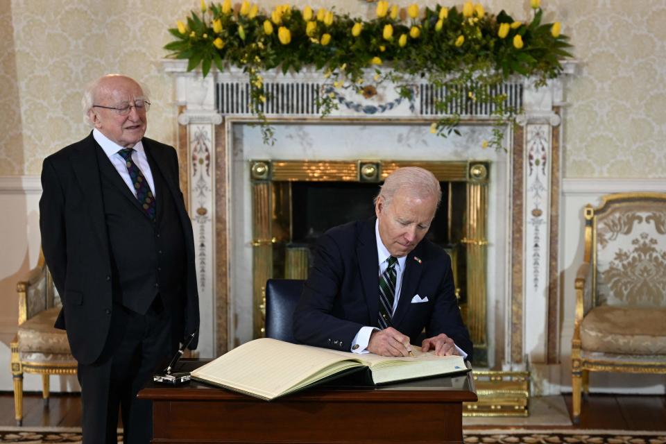 President Joe Biden signs the guest book as Ireland's President Michael D Higgins stands by, at Aras an Uachtarain in Dublin, on April 13, 2023, during his four day trip to Northern Ireland and Ireland commemorating the 25th anniversary of the "Good Friday Agreement".