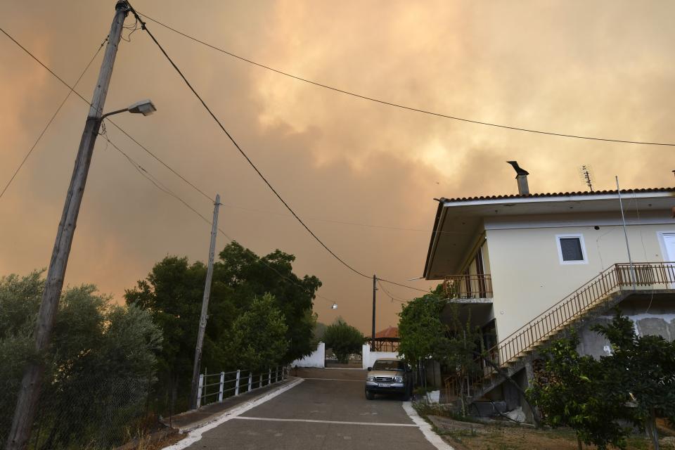 A wildfire approaches a village near Pyrgos town, western Greece, Thursday, Aug. 5, 2021. Wildfires rekindled outside Athens and forced more evacuations around southern Greece Thursday as weather conditions worsened and firefighters in a round-the-clock battle stopped the flames just outside the birthplace of the ancient Olympics. (Giannis Spyrounis/ilialive.gr via AP)