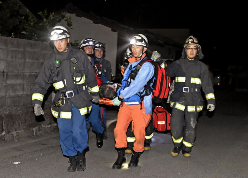 Firefighters carry an injured person