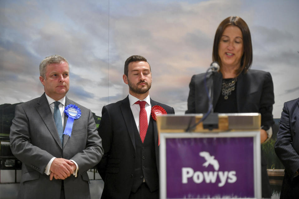 Conservative candidate Chris Davies, left, looks as Liberal Democrats' Jane Dodds, right, gives a winner's speech after winning the seat in the Brecon and Radnorshire by-election at the Royal Welsh Showground in Llanelwedd, Builth Wells, Wales Friday Aug. 2, 2019. (Ben Birchall/PA via AP)