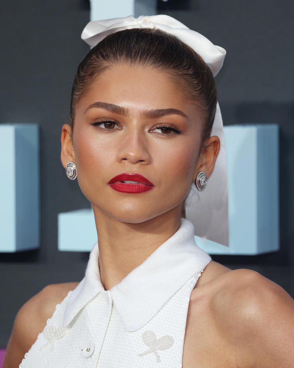 Zendaya in a top with a bow headband and diamond earrings