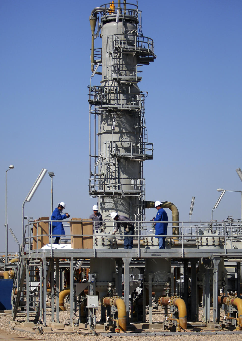 FILE - In this Tuesday, Feb. 21, 2017 file photo, oil laborers work at West Qurna oil field near the city of Basra, Iraq. An Iraqi oil official says employees of energy giant Exxon Mobil have started evacuating an oil field in the southern province of Basra, amid rising tensions between the United States and Iran. The first group left two days ago and another batch left early Saturday May 18, 2019. (AP Photo/Nabil al-Jurani, File)