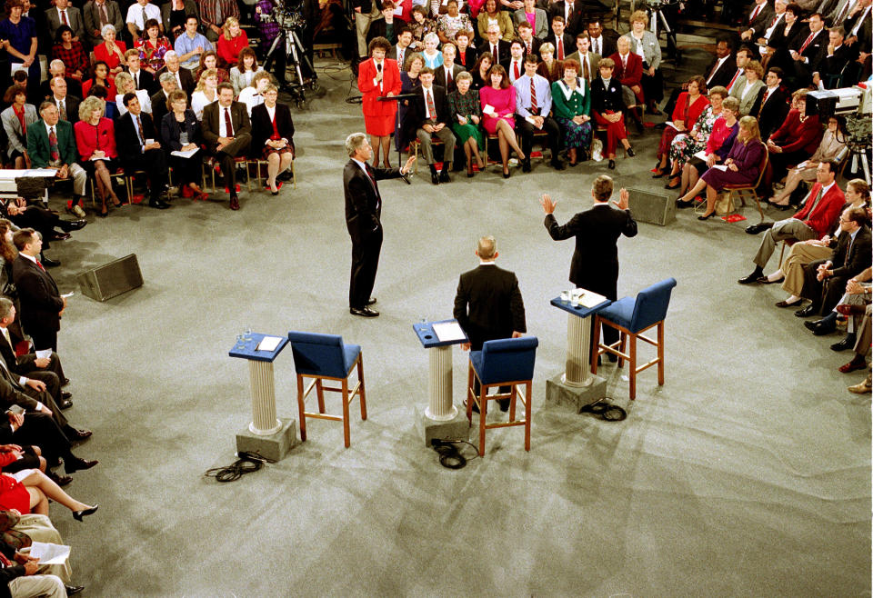 FILE - In this Oct. 15, 1992 file photo, Moderator Carole Simpson, background center, presides over the Presidential debate between, from left, Democratic presidential candidate Bill Clinton, Independent candidate Ross Perot, center, and Republican candidate, President George H.W. Bush, at the University of Richmond, Va. The every-four-years ritual of a national "town hall" style debate began as a nerve-racking experiment in live television. Simpson was so nervous about turning over the microphone to regular folks and their questions that she spent days mapping out the presidential candidates and their issues on "a zillion 3-by-5 cards," in case she had to take over the questioning herself. (AP Photo/Joe Marquette, File)