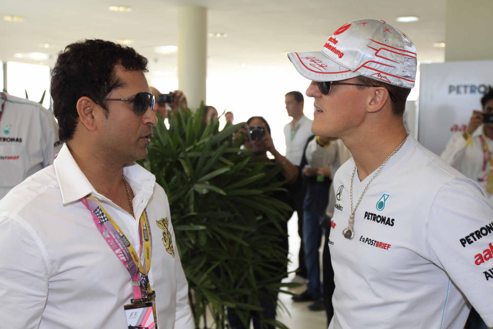 ----EDITORS NOTE---- RESTRICTED TO EDITORIAL USE MANDATORY CREDIT "AFP PHOTO / HO / PERFECT RELATIONS " NO MARKETING NO ADVERTISING CAMPAIGNS - DISTRIBUTED AS A SERVICE TO CLIENTS Mercedes driver Michael Schumacher of Germany and Indian cricketer Sachin Tendulkar (L) interact during the Formula One Indian Grand Prix in Greater Noida on October 30, 2011. World champion Sebastian Vettel made history by winning India's first ever Formula One with ease as McLaren's Jenson Button tightened his grip on the championship's second place. AFP PHOTO/PERFECT RELATIONS (Photo credit should read HO/AFP/Getty Images)