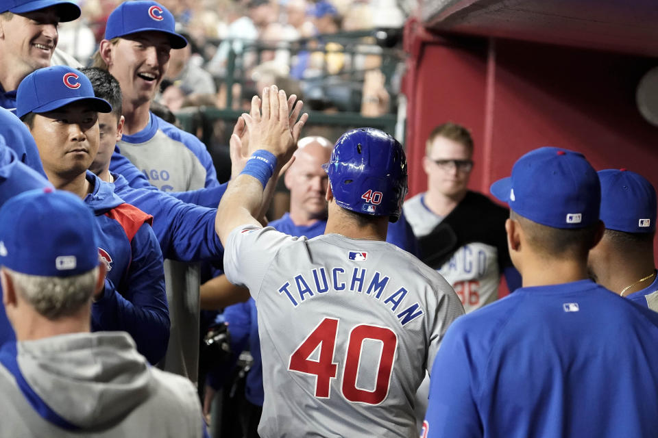 Chicago Cubs' Mike Tauchman (40) gets high-fives from teammates after scoring against the Arizona Diamondbacks during the fifth inning of a baseball game Wednesday, April 17, 2024, in Phoenix. (AP Photo/Darryl Webb)