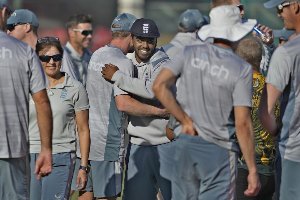 England's Rehan Ahmed, center, is congratulated by team officials after receiving test cap prior to start of third test cricket match between England and Pakistan, in Karachi, Pakistan, Saturday, Dec. 17, 2022. (AP Photo/Fareed Khan)