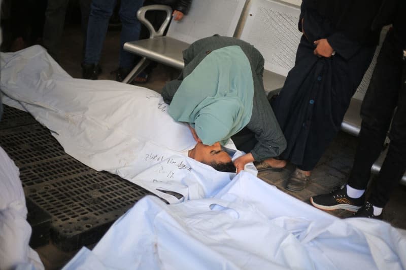 A woman griefs near the dead bodies of Palestinians, killed in Israeli bombardment on lands housing displaced persons, in Al-Najjar hospital. Mohammed Talatene/dpa