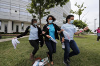 Healthcare workers at New Orleans East Hospital wave handkerchiefs and dance to a jazz serenade, as a tribute for their care of COVID-19 patients, by the New Orleans Jazz Orchestra, outside the hospital in New Orleans, Friday, May 15, 2020. A New York woman collaborated with the New Orleans Jazz Orchestra to put on what she calls a stimulus serenade to give moral support to front-line hospital workers and COVID-19 patients in New Orleans (AP Photo/Gerald Herbert)