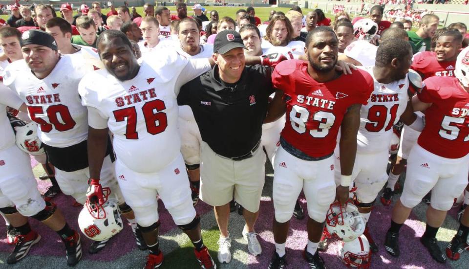 N.C. State head coach Dave Doeren, center, along with Deylan Buntyn (76), left, Anthony Talbert (83) and the rest of the team listen to the alma mater after the Kay Yow Spring Football game in April 2013.
