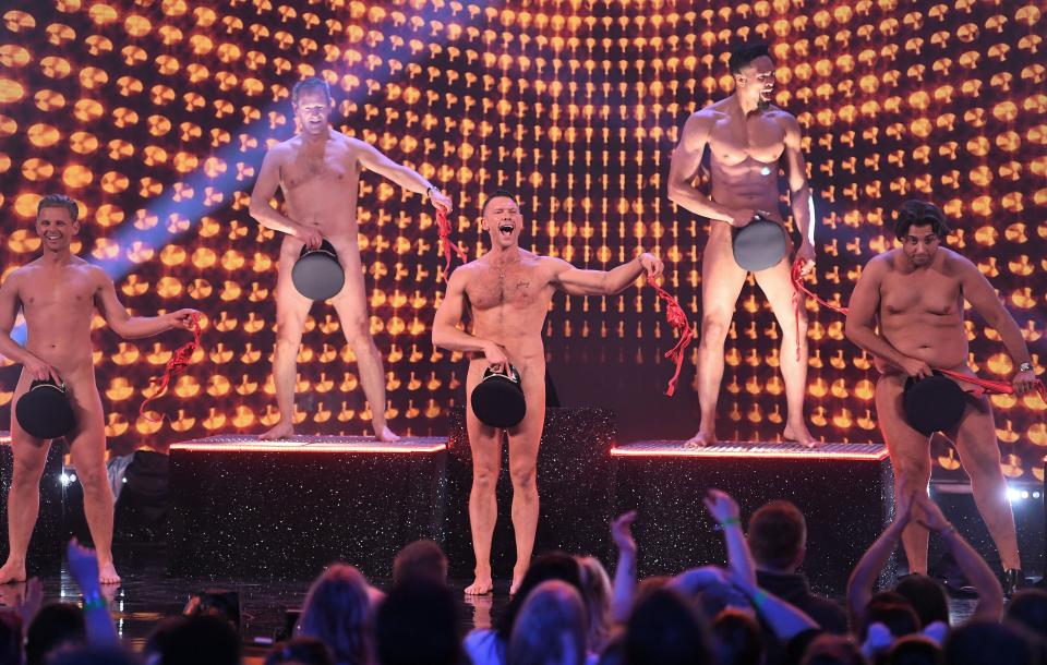 The blokes strip off for the cameras in the name of cancer awareness. (REX)