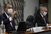 Senators Omar Aziz, left, and Renan Calheiros attend a session by their commission investigating the government's management of the COVID-19 pandemic at the Federal Senate in Brasilia, Brazil, Tuesday, Oct. 26, 2021. (AP Photo/Eraldo Peres)